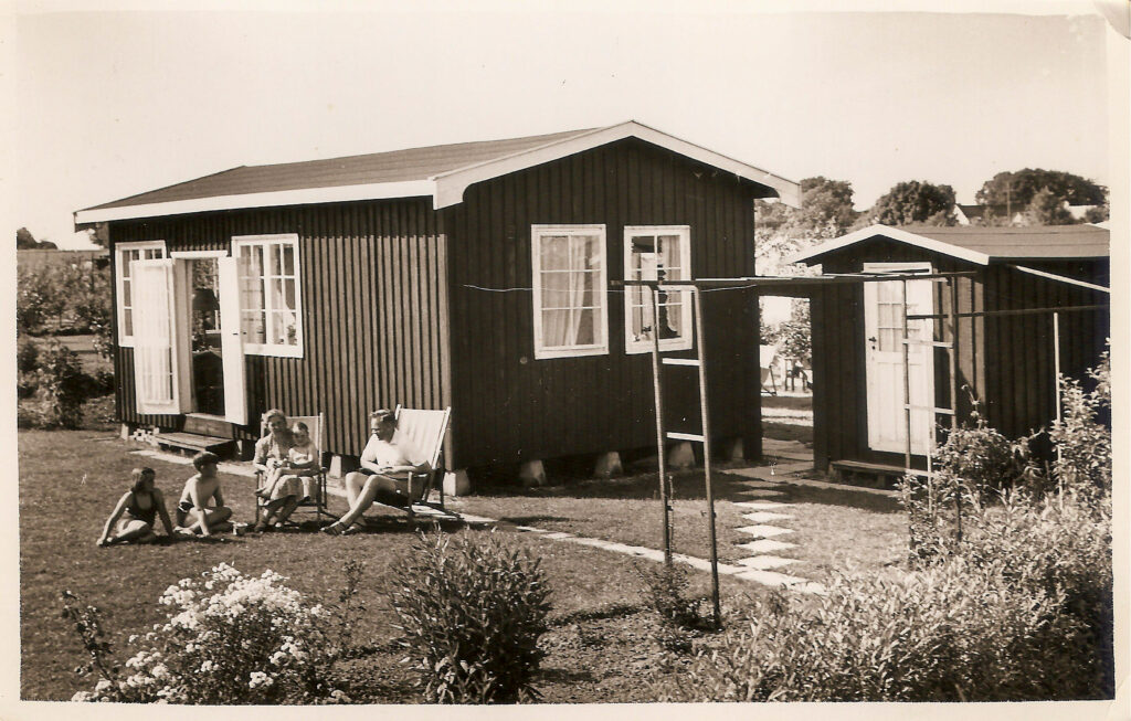 Henrik Jensen, Inger Jensen med sønnen Erik, samt Svend Jensen og Birte Jensen på græsset. Sommerhuset er nybygget på Tjornevænget i Skovlunde